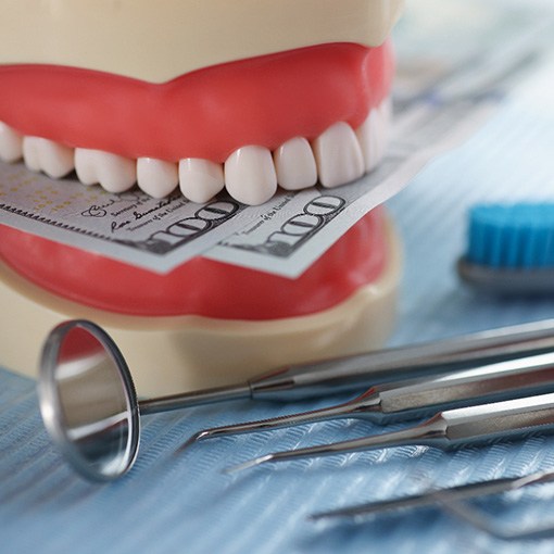 Model of dentures holding money