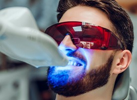 A man receiving an in-office teeth whitening treatment