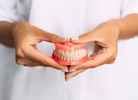 Lady presents viewer with dentures