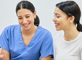 Patient and dental team member looking at clipboard