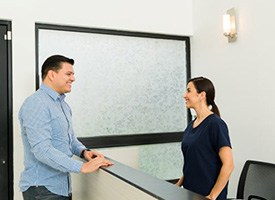 Team member helping patient at dental office front desk