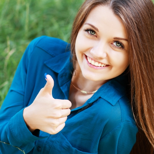 Woman giving thumbs up after receiving dental care
