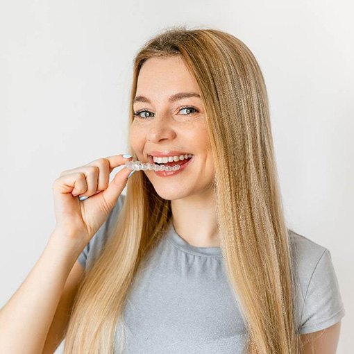 Blonde woman putting in a Candid clear aligner in Chevy Chase, MD