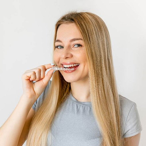 Blonde woman putting in a Candid clear aligner in Chevy Chase, MD