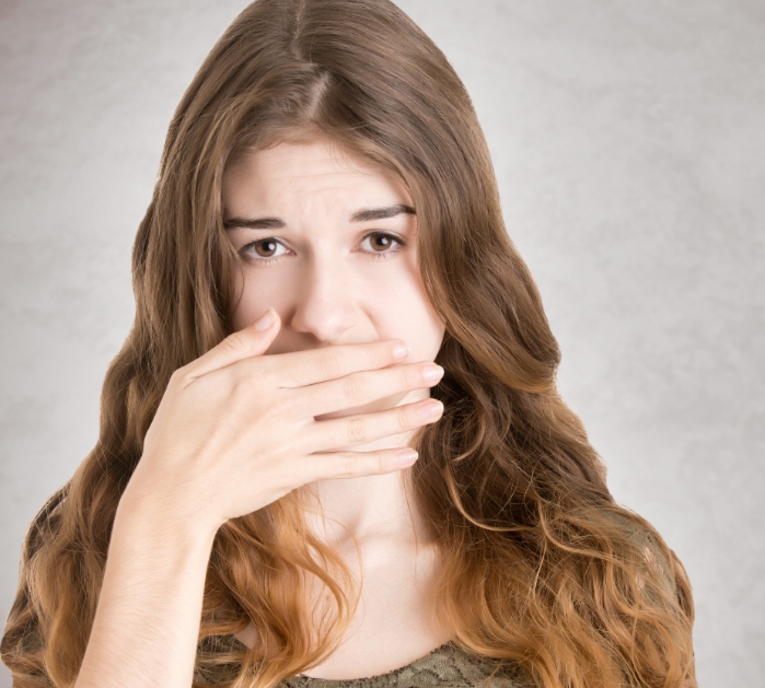 Woman covering her smile before restorative dentistry