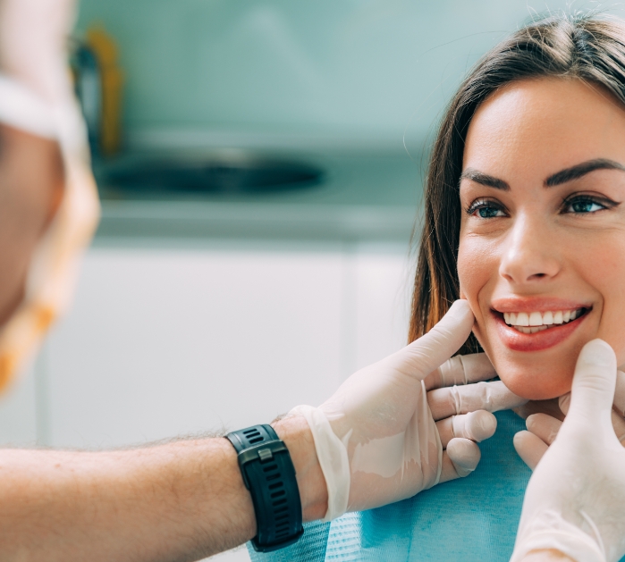 Dentist examining woman's smile after cosmetic dentistry