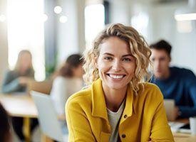 Woman in yellow jacket smiling at work