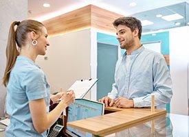 Dental assistant smiling while taking patient's information