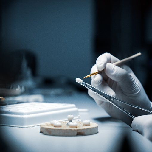 dental lab technician making a dental crown 