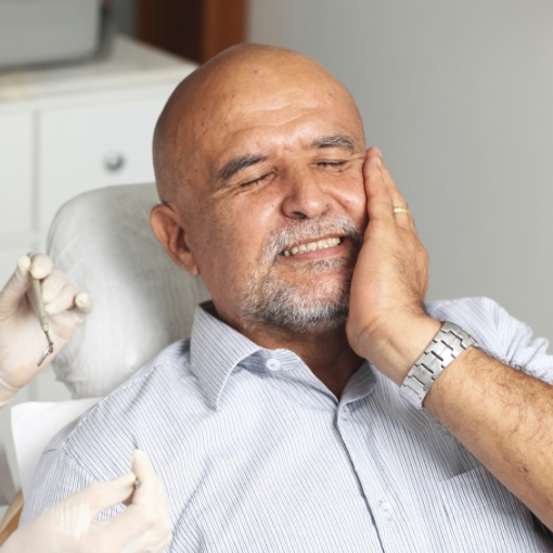 Man in pain during emergency dentistry treatment