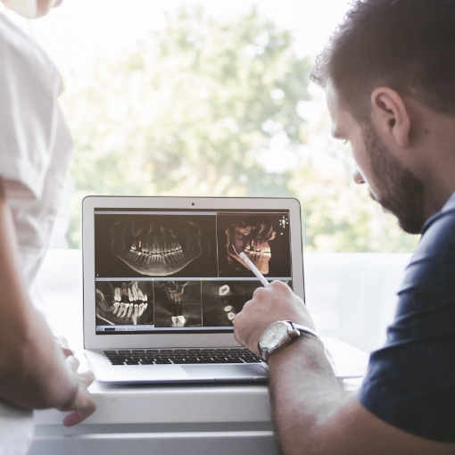 Dentist reviewing the cost of dental implants for tooth replacement