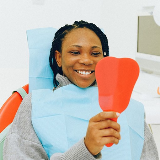 Female patient looking in dental mirror