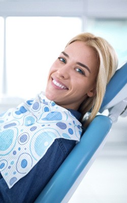 Woman smiling while visiting dentist near Heights Village