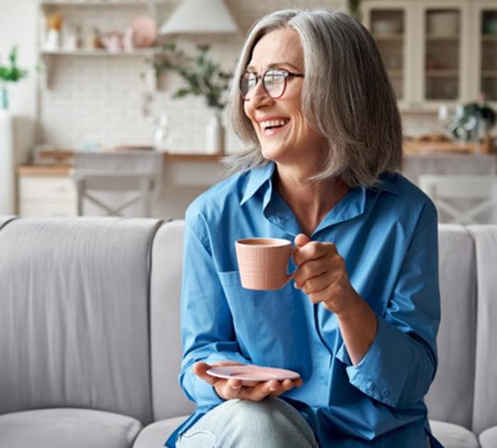 a woman smiling while drinking coffee
