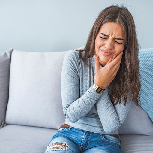 Woman with a toothache on the couch