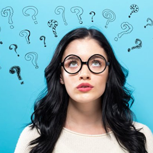 Woman looking up at several question mark graphics