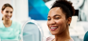 Woman looking at her beautiful smile after cosmetic dentistry