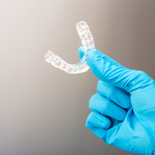 Hand holding a clear occlusal splint