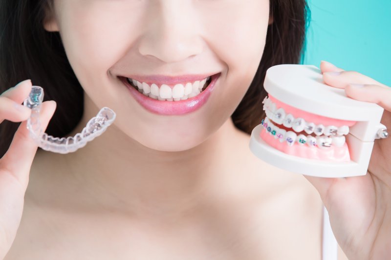 young woman holding an Invisalign aligner