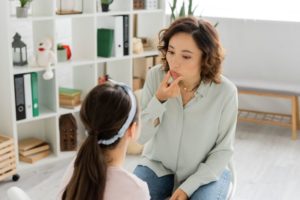 Myofunctional therapist working with young girl