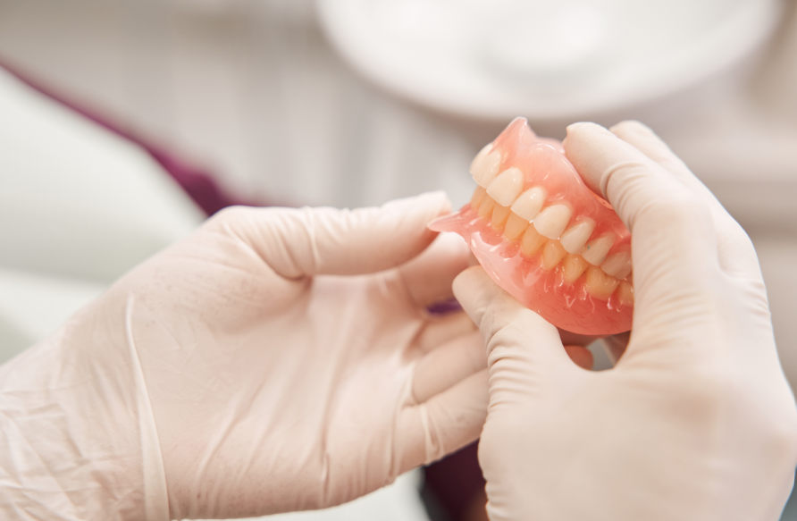 Dentist holding dentures